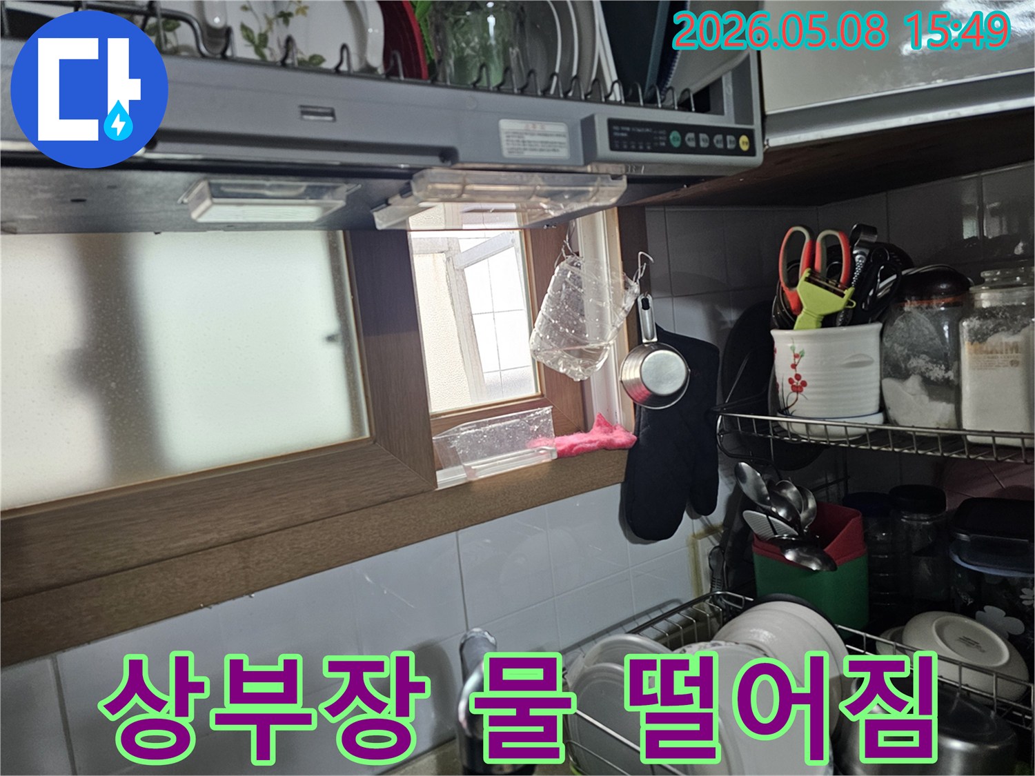 주방 싱크대 상부장 아래에서-물이 계속 떨어지고 있는-긴급 누수 현장 이미지