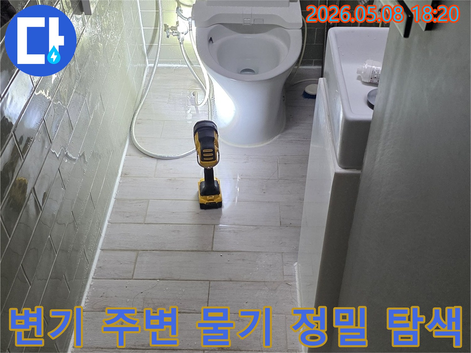 욕실 변기 주변에 고인 물기를-전문가가 밝은 조명으로 정밀하게 탐색하는 모습