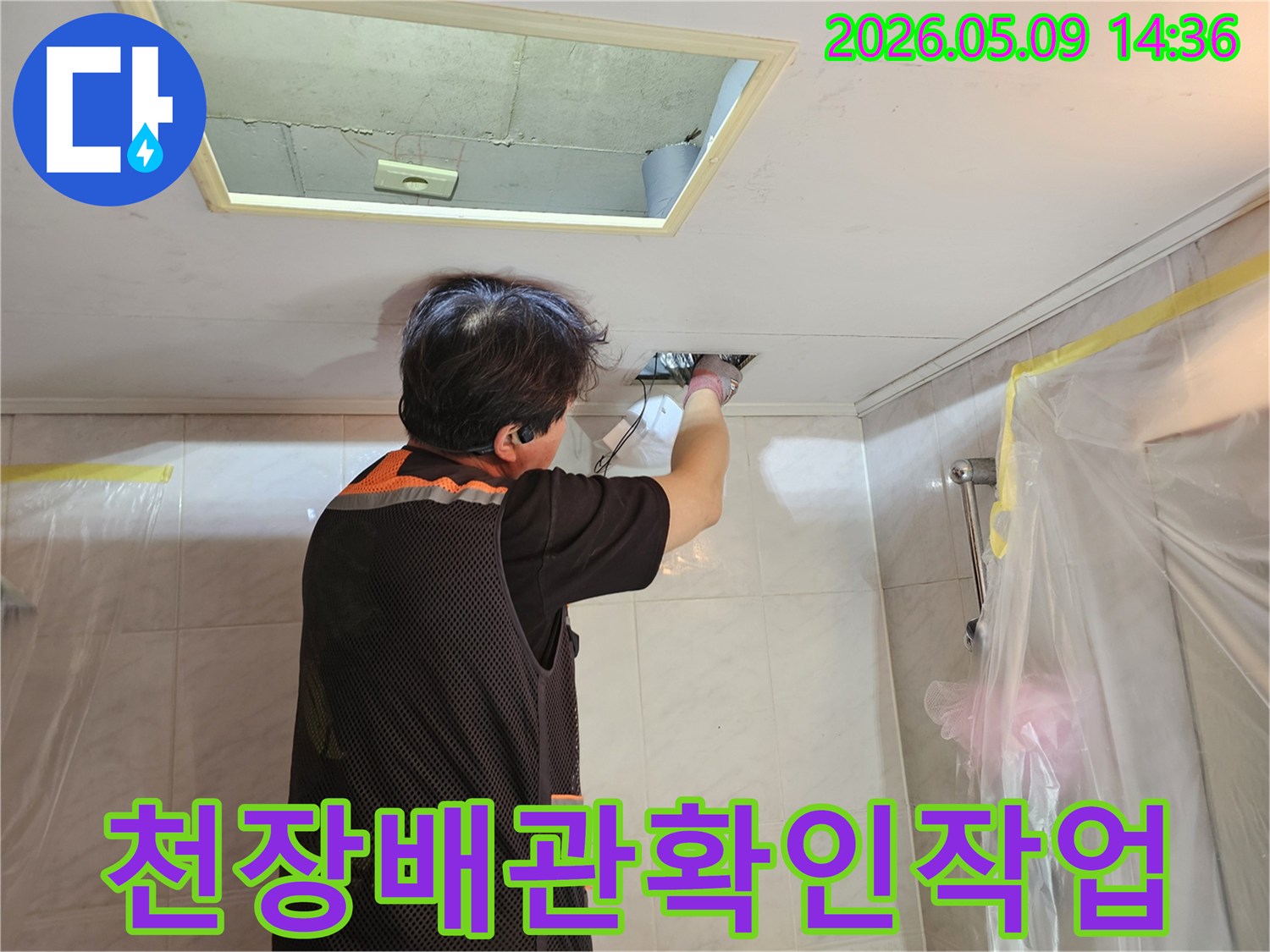 숙련된-누수-기술자가-천장-점검구를-통해-배관의-누수-여부를-면밀히-살피는-모습