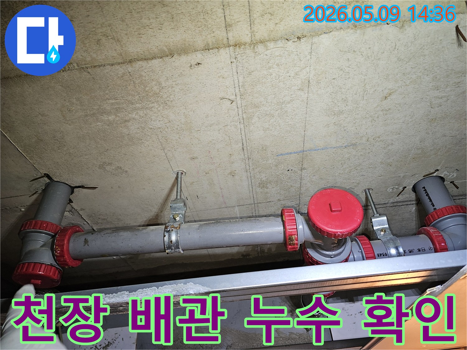 콘크리트 천장에 고정된 배관의-누수 여부를 확인하기 위한-전문가의 점검 모습