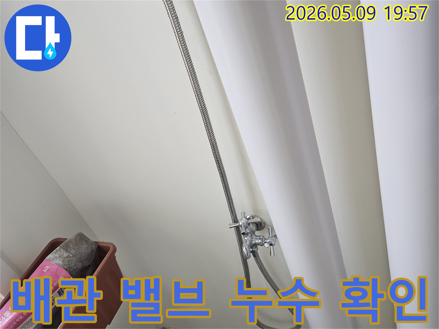 누수 공사 현장에서-배관 밸브와-연결된 호스의-상태를 확인하는-기술자의 모습입니다