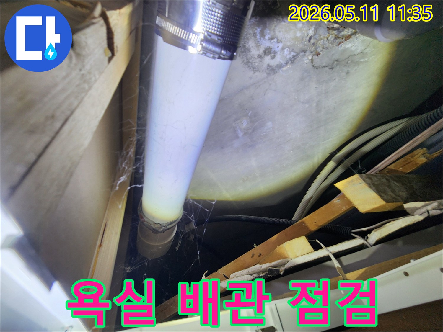 욕실 하부의 배관에서-발견된 습기 흔적과-오염된 표면을-자세히 관찰하는 이미지입니다.