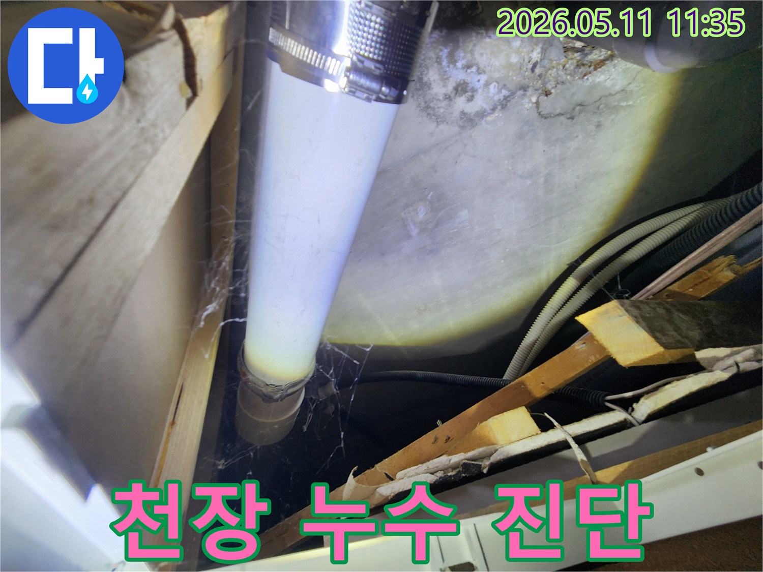 천장 내부의 배관에서-발견된 물기 자국과-주변 습기 흔적을-면밀히 조사하는 장면입니다.
