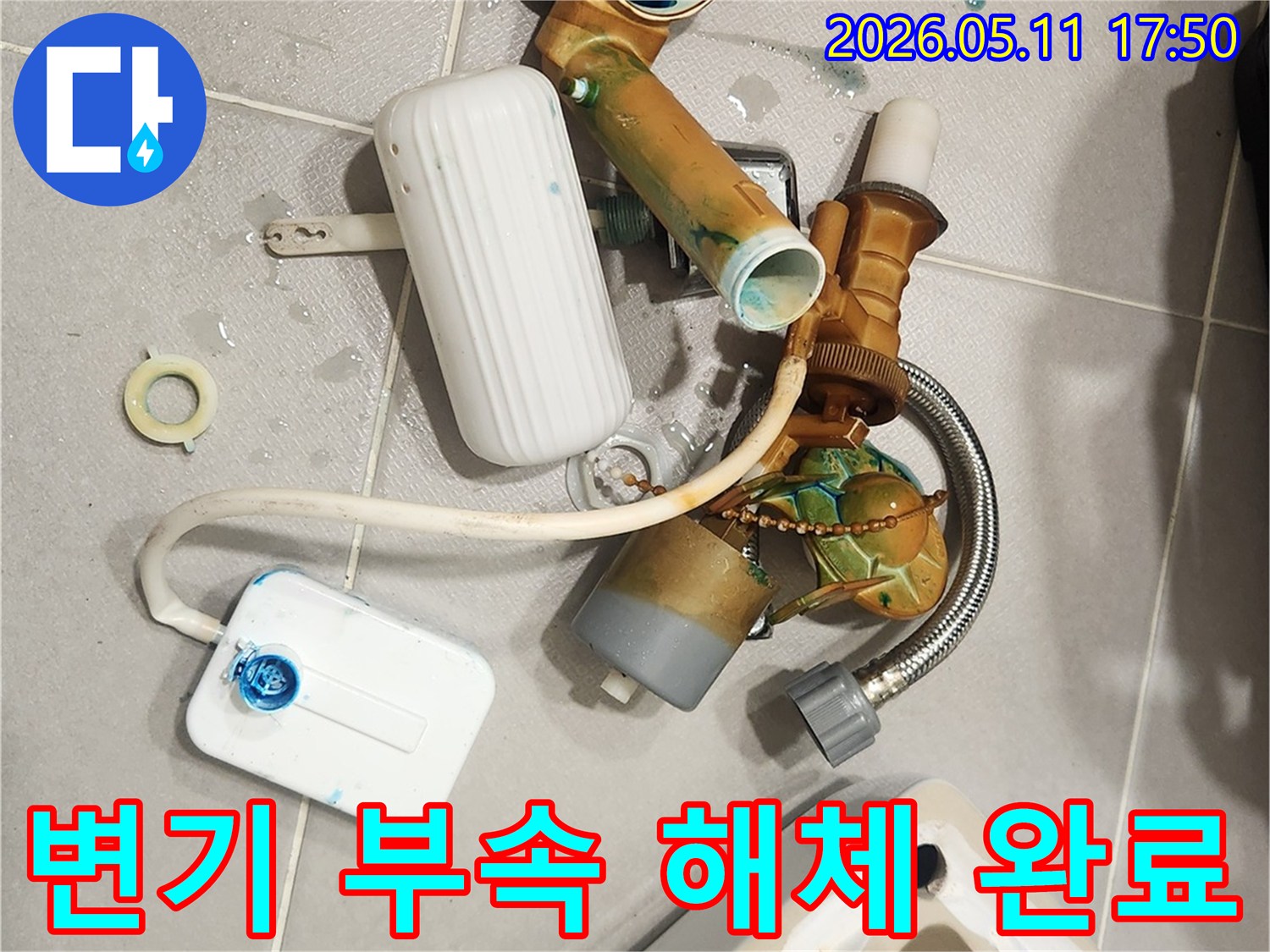 안방 변기에서 발생한 물샘 문제를 해결하기 위해-오래된 변기 부속들이 해체되어 바닥에 놓여 있는 모습입니다-새 부품으로 교체하여 변기를 수리할 예정입니다