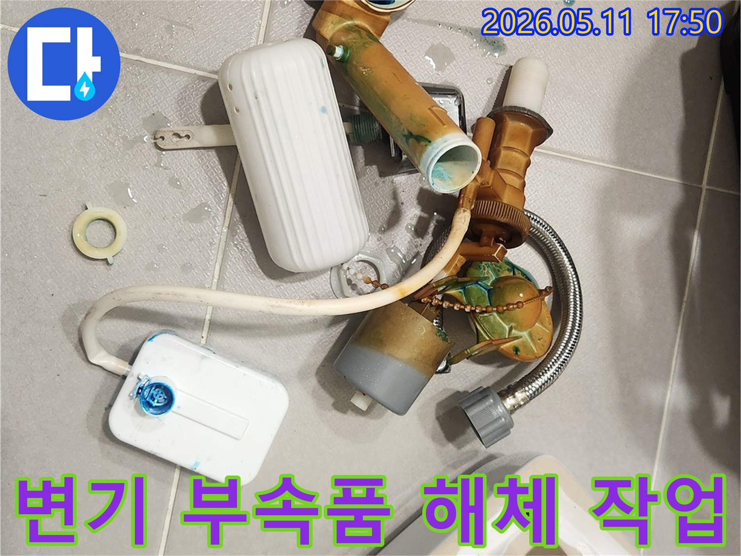오래되어 부식된 변기 내부 부속들이-바닥에 가지런히 놓여 있는 모습입니다-새 부품으로 교체하기 위한 준비 과정입니다
