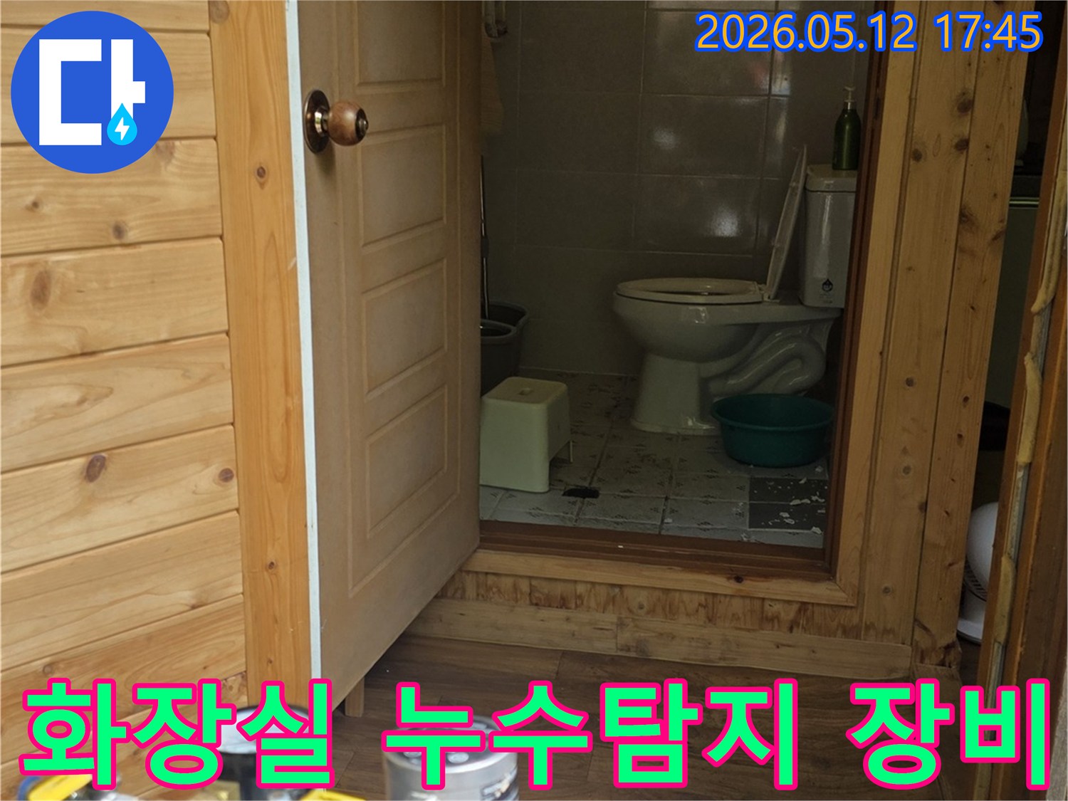 화장실 문 앞에서-누수 탐지 장비가-정밀하게-작동 중인 모습