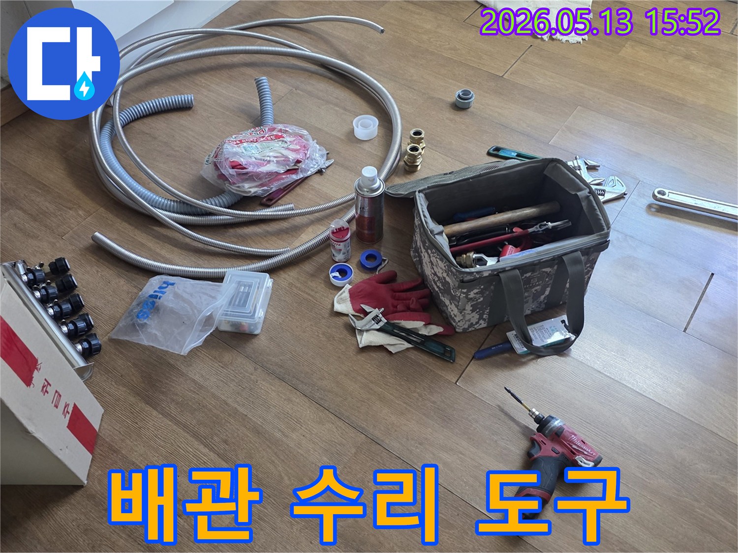 누수-수리-작업에-사용될-다양한-배관-공구와-새로운-파이프-자재들이-바닥에-정돈된-모습