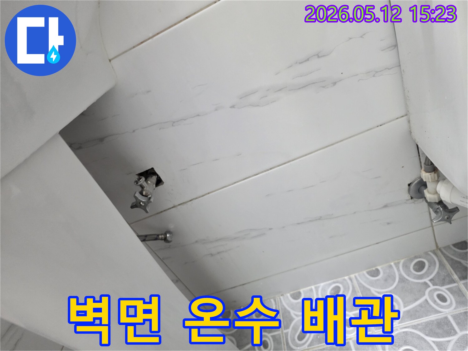 갈현동 아파트에서-발생한 벽면 온수 배관 누수의-근본 원인을 파악하기 위해-배관 연결 부위를-정밀하게 검사하는 장면입니다.