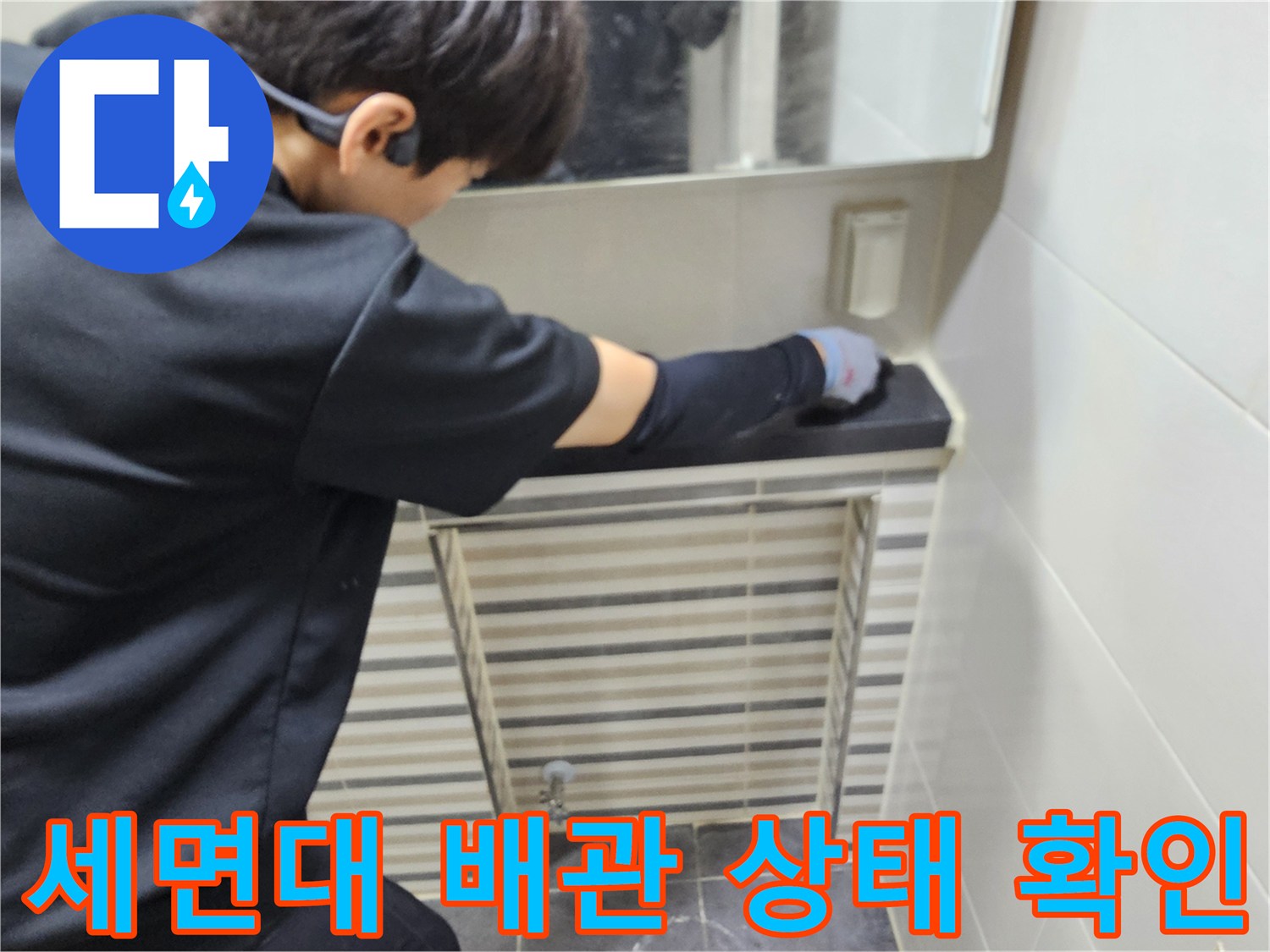 엔지니어가 세면대 밑 배관 부위를 손으로 만지며 점검하는 모습