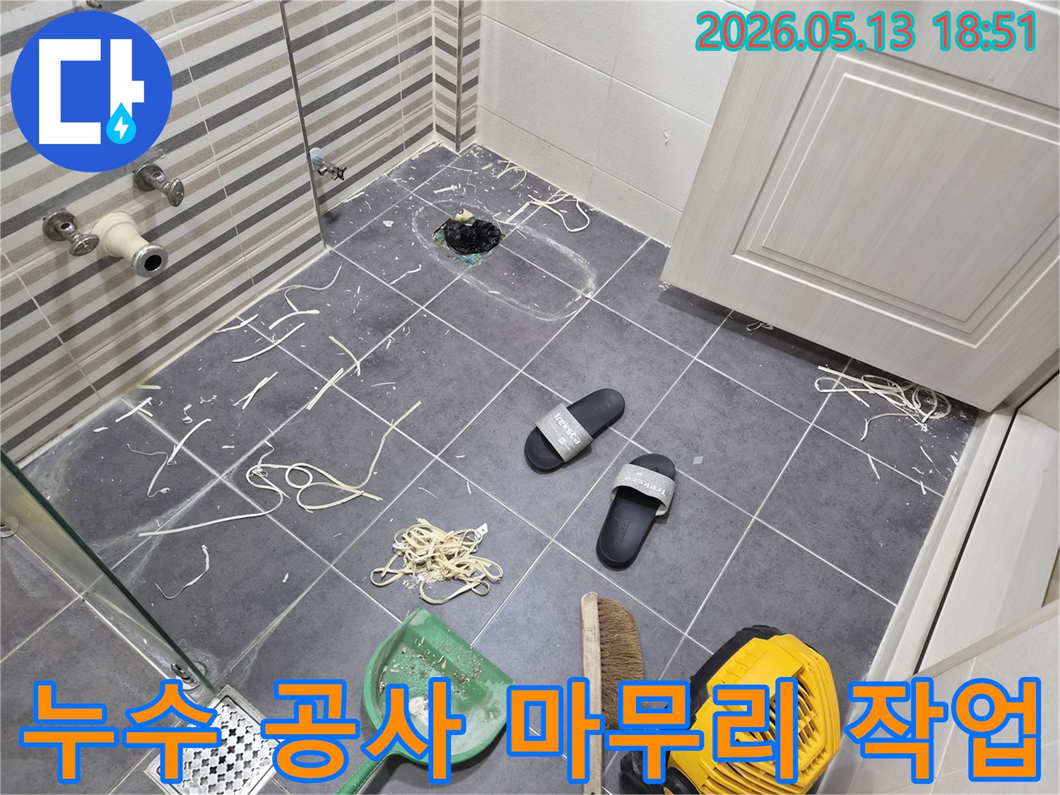 이 이미지는-인천 연수구 럭키송도아파트의-화장실 누수 공사 현장에서-작업 후 발생한 잔해들을-정리하고 청소하는-모습을 보여줍니다