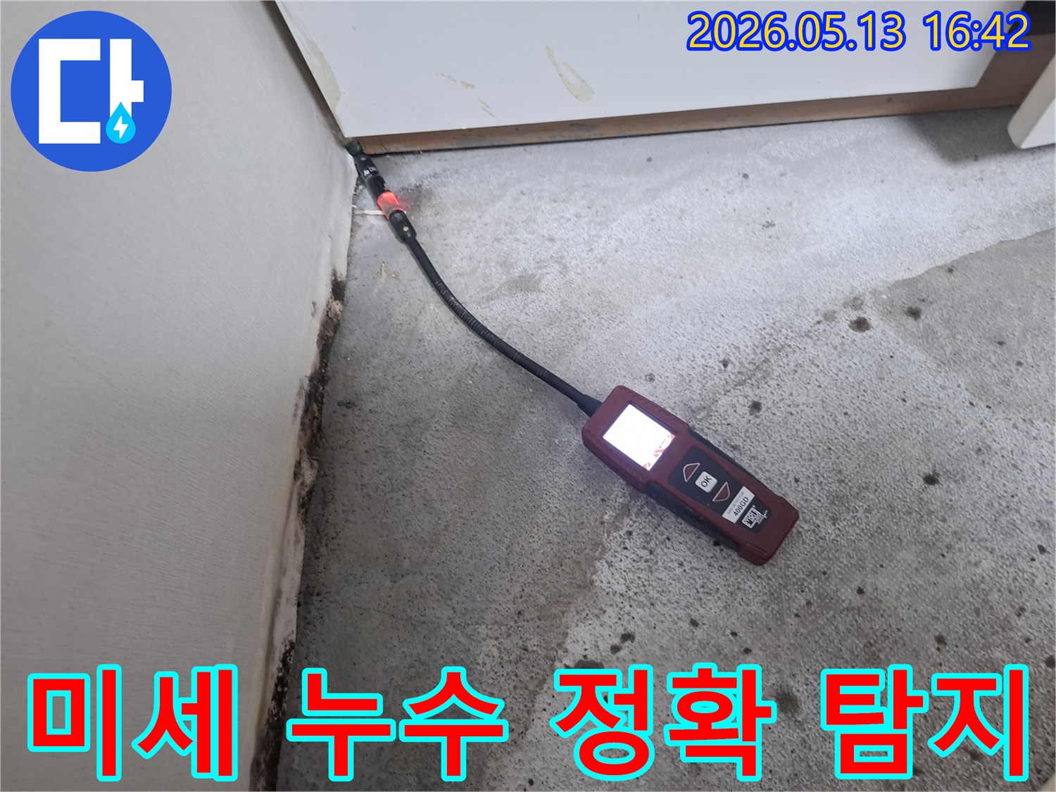 벽면과 바닥 경계에서-미세 누수를 탐지하기 위해-가스 탐지 장비를 사용하는 장면입니다.