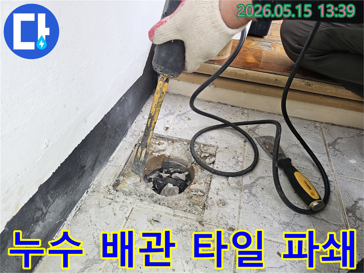 누수 탐지 후 정확한 공사를 위해 배관 주변 타일을 파쇄하는 작업자의 모습