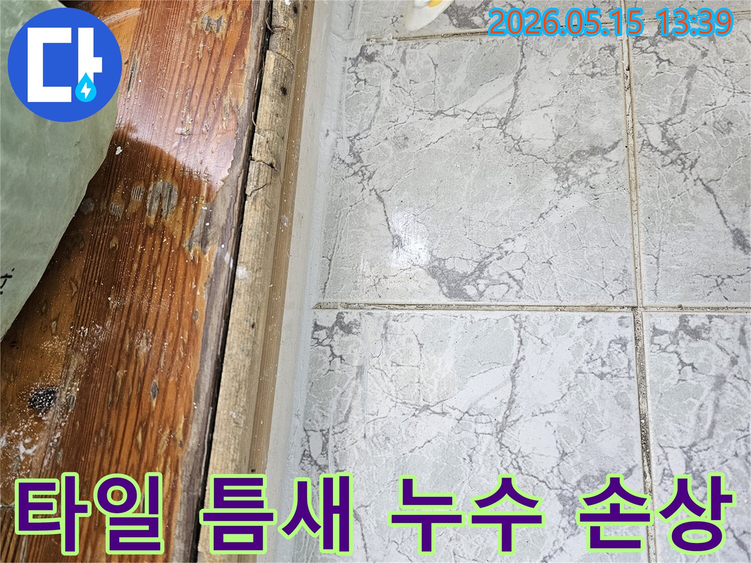 이 이미지는-의정부 신곡동 아파트에서 발견된-타일 틈새를 통한 누수로 인해-목재 하단부가 손상된 모습을 담고 있습니다