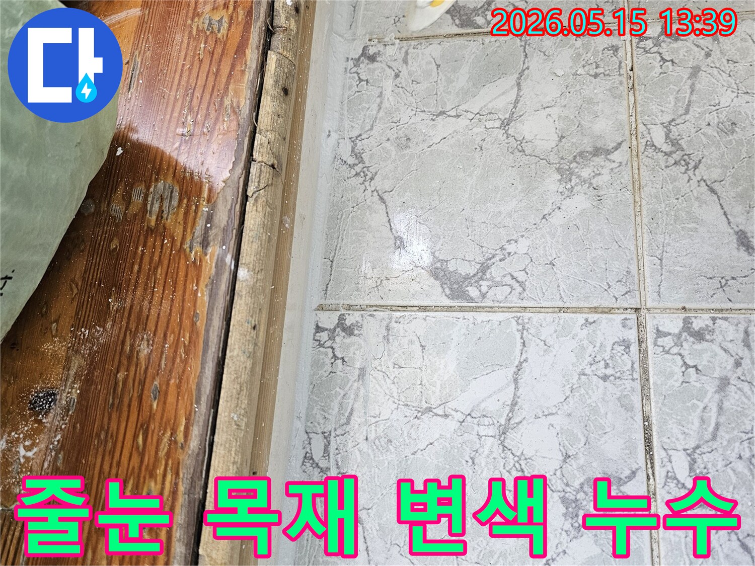 이 이미지는-의정부 신곡동 아파트에서 발생한-누수로 인해 타일 줄눈과 목재 마감재가 변색된 모습을 보여줍니다