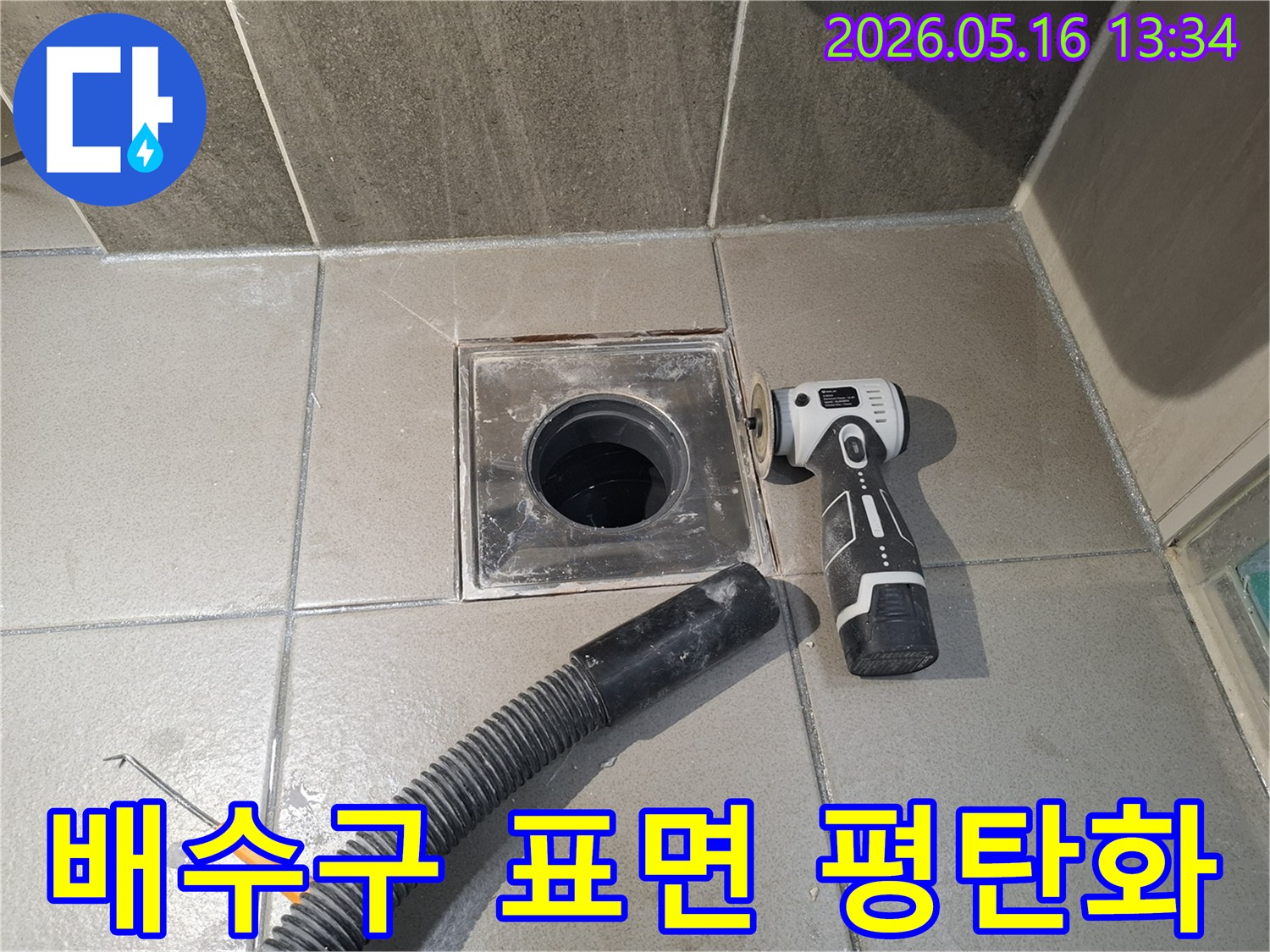 누수 엔지니어가 욕실 배수구 주변의 누수 해결을 위해-전동 공구로 표면을 처리하고-평탄화 작업을 진행하여-새로운 방수 시공을 위한 최적의 상태를 만들고 있습니다