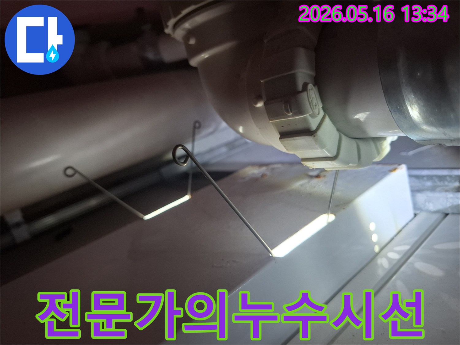누수 탐지 전문가가-배관의 미세한 누수 지점을-집중적으로 관찰하며-진단하는 모습입니다