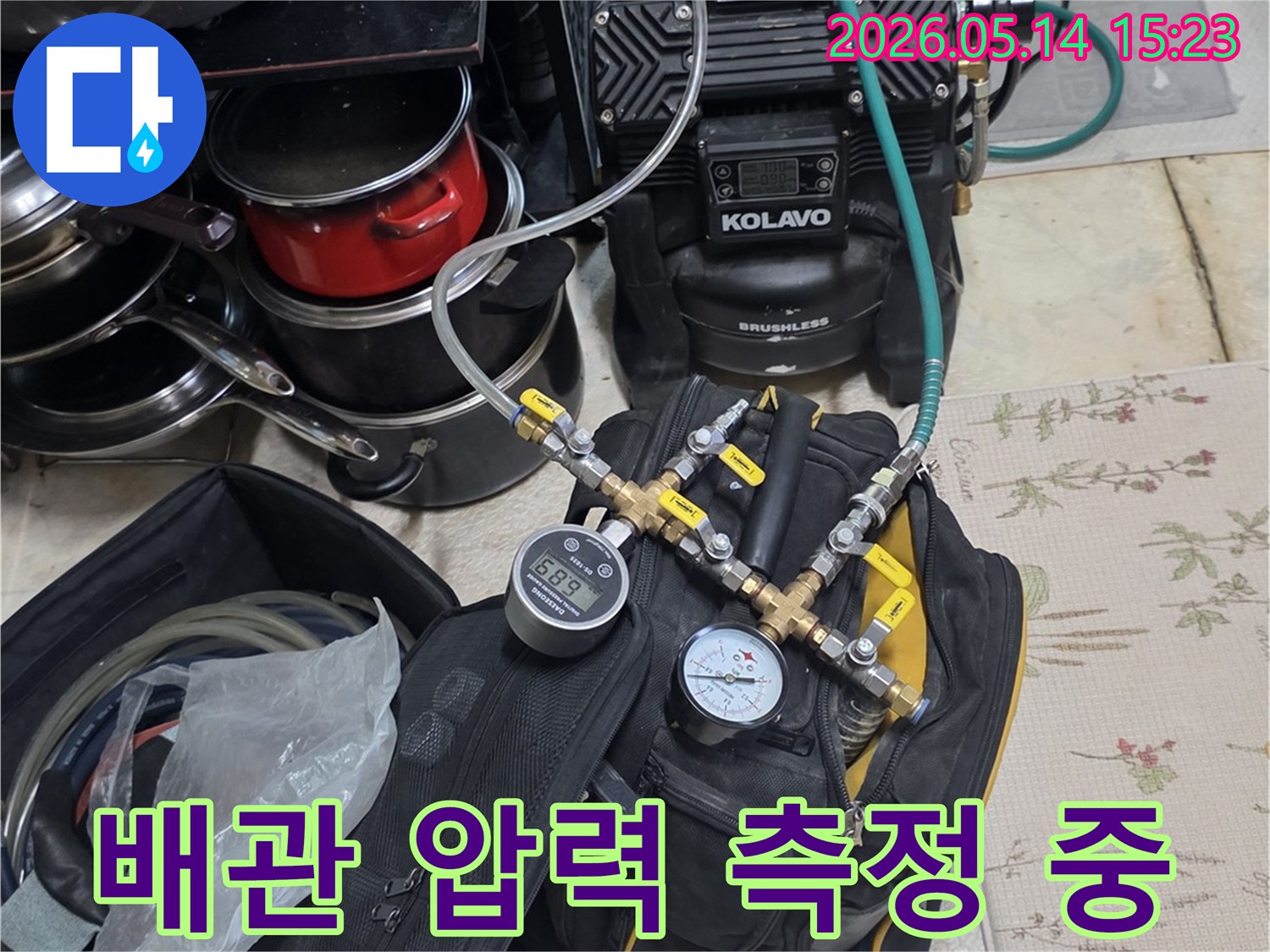 누수 탐지를 위해 배관에 연결된 압력 테스트 장비가 작동 중인 모습