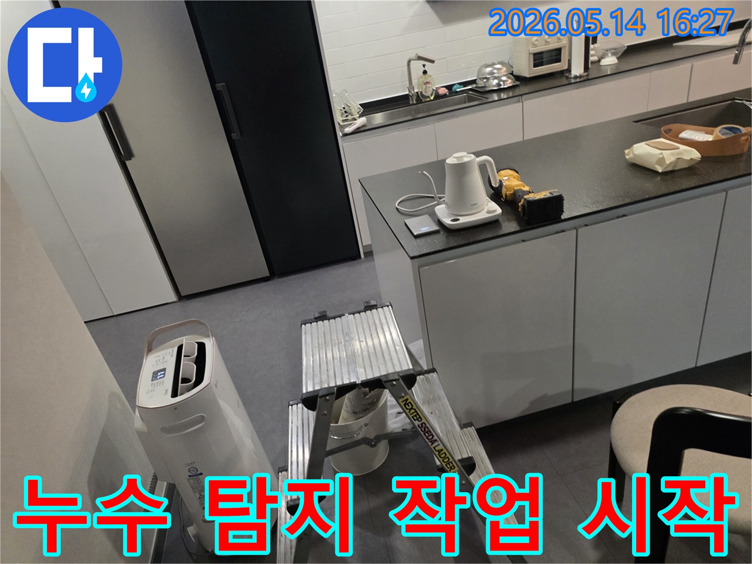 누수 탐지 전문가가-고객님의 주방에서-작업 전-장비 점검과-환경 확인을 하고 있습니다.