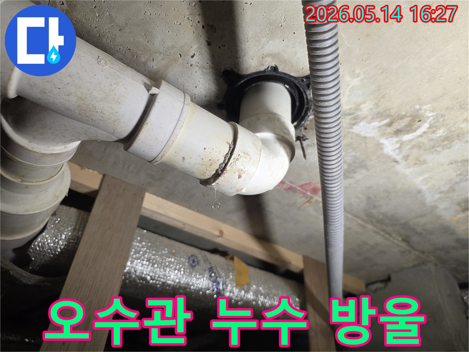 천장 아래 설치된 오수관 이음새에서 물방울이 떨어지는-위생상 문제가 될 수 있는 누수 현장 사진