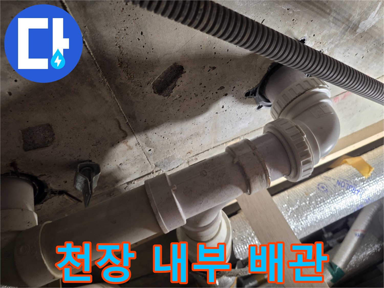 천장 점검구 내부-배수 파이프와 전선관 모습