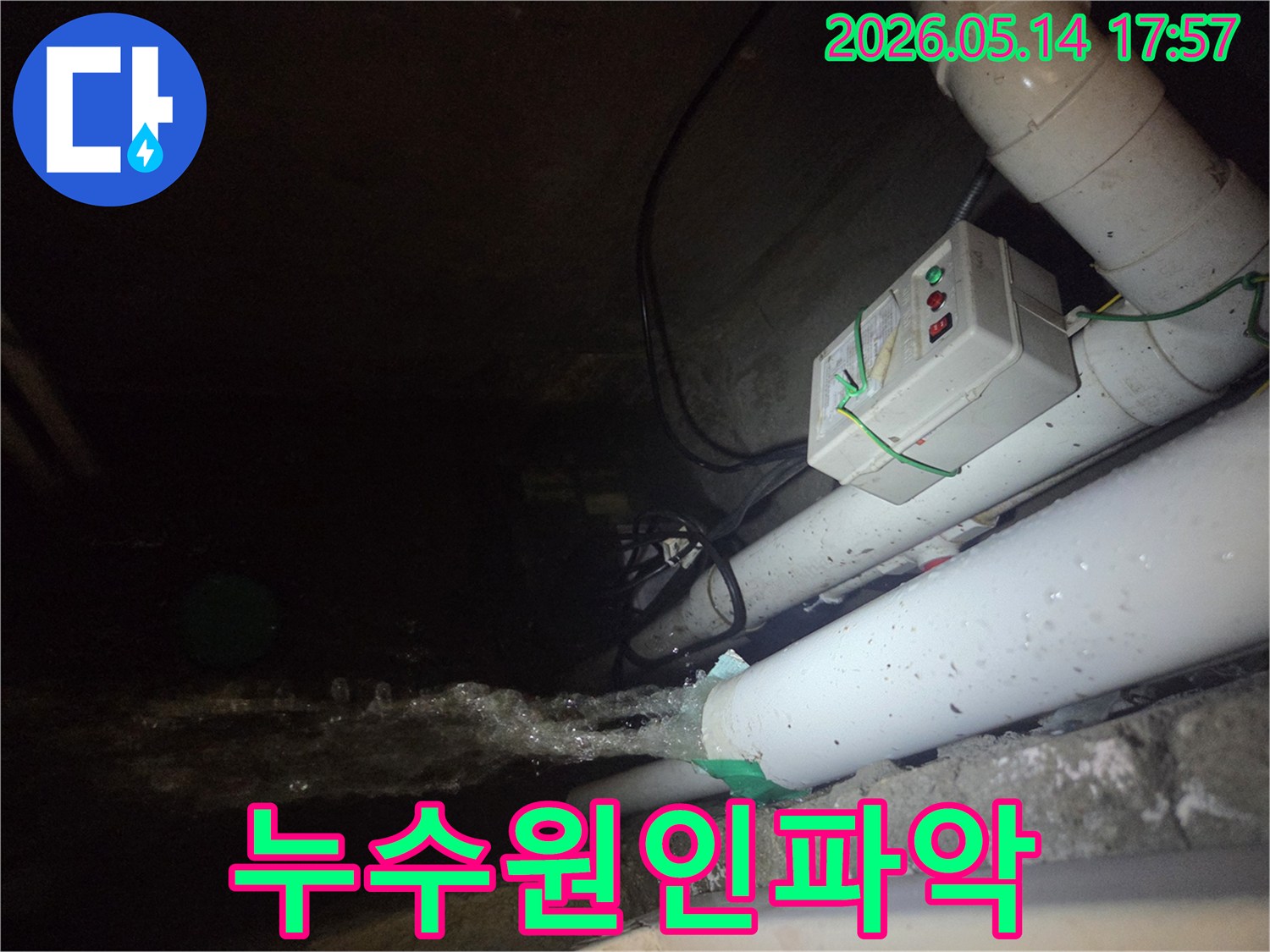 어두운 지하 공간에서-파이프에서 물이 강하게 뿜어져 나오는-누수 현장을 보여주는 사진입니다-전기 제어 박스와 배관들이 함께 보입니다.