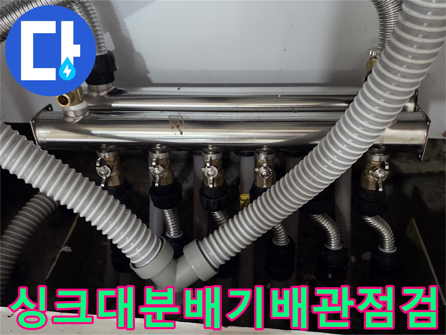 싱크대 하부장 내부의 보일러 분배기와 연결된 은색 주름관 상태 확인