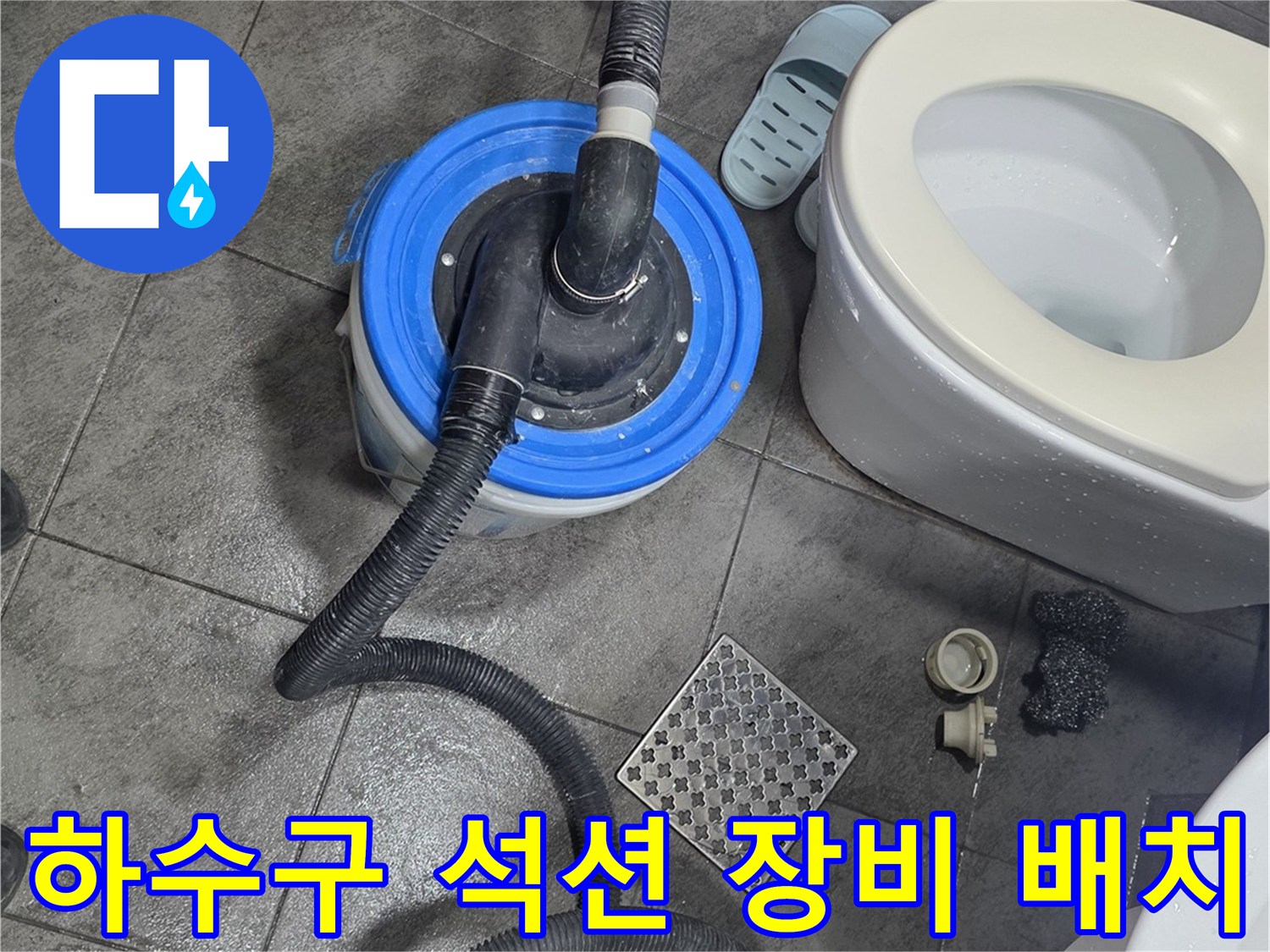 배수구 막힘을 해결하기 위해 석션 호스를 연결하여 작업 중인 사진입니다.