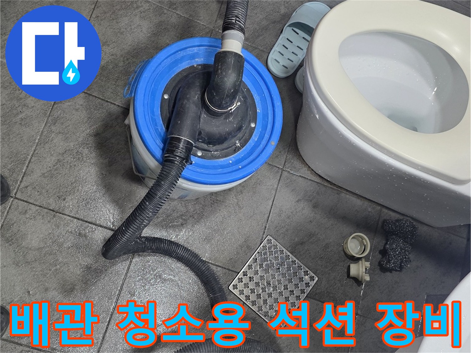 변기 및 세면대 주변 타일 바닥에 배치된 작업용 석션 호스