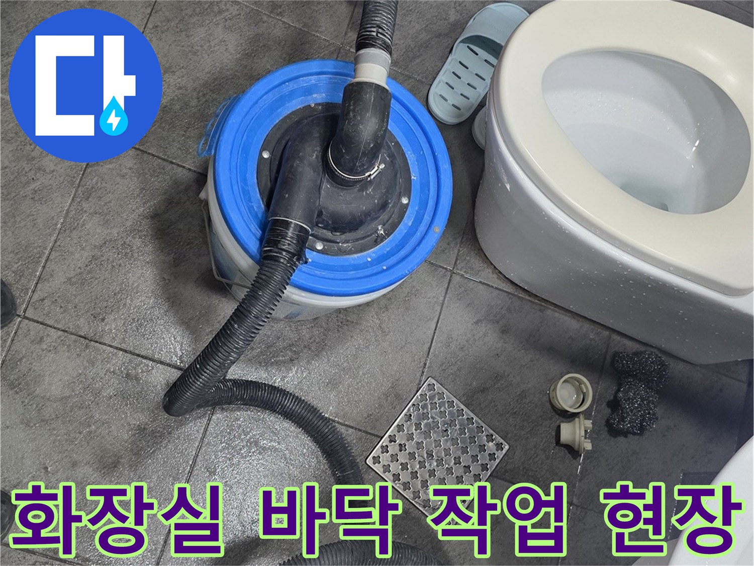 변기와 세면대가 있는 화장실 바닥에 설치된 석션 장비와 호스