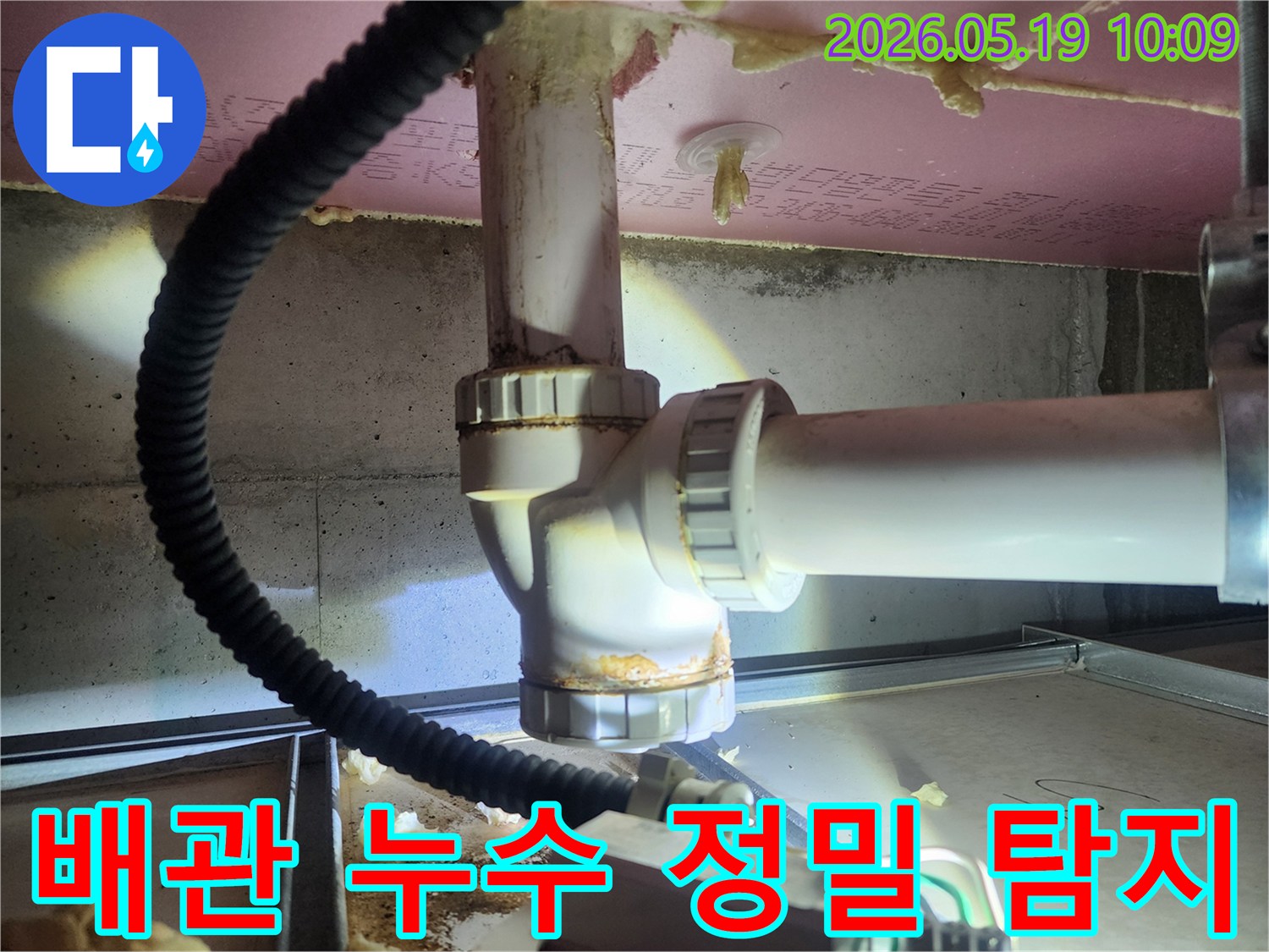 누수 엔지니어가 배관 연결부의 부식과 물기 흔적을 확인하며-누수 지점을 정확히 파악하기 위한 진단 작업을 수행하고 있습니다
