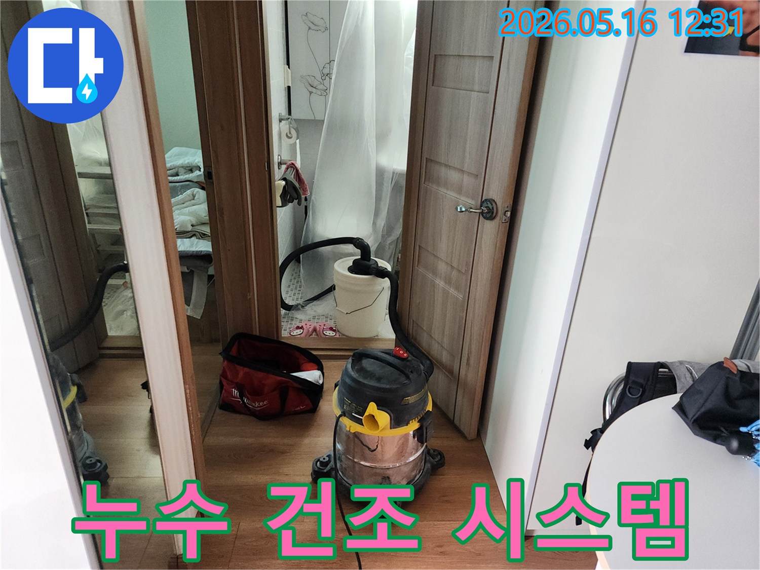 누수 수리 완료 후-바닥에 남은 물기를-전문 습식 청소기로 흡입하여-건조하는 현장 사진입니다.