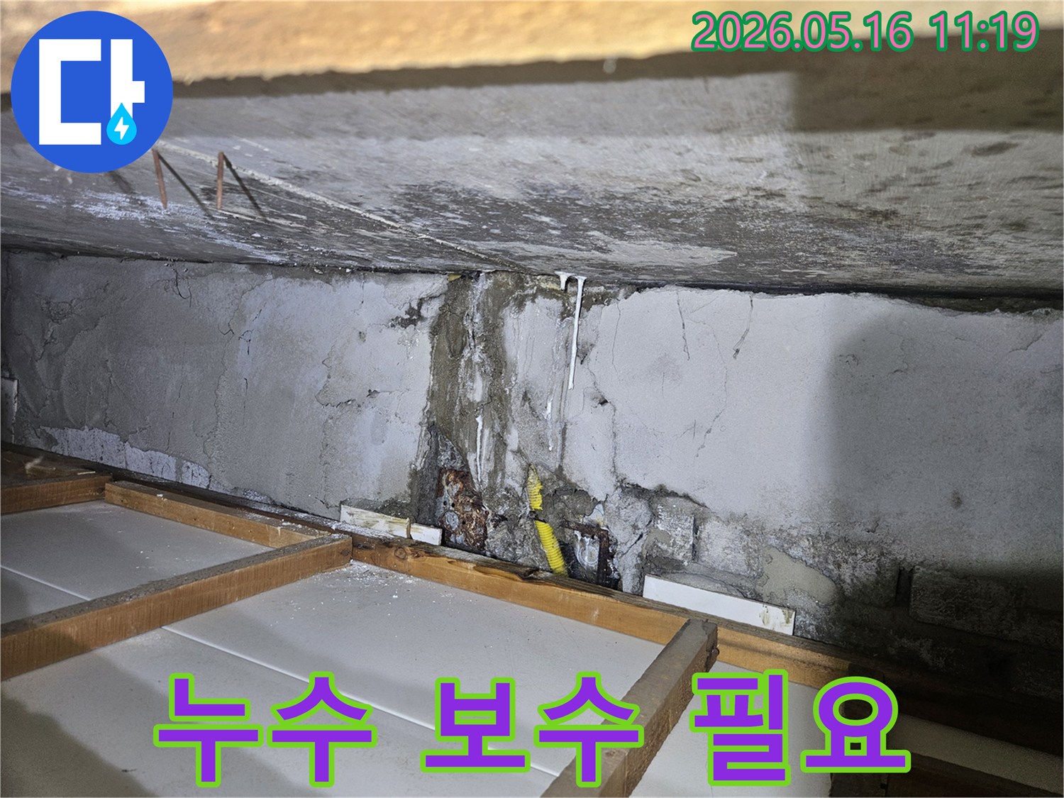 천장 콘크리트 벽면에서-물이 새어 흘러내린-누수 흔적을 보며-건물 구조 손상 전-빠른 보수가 필요함을 강조