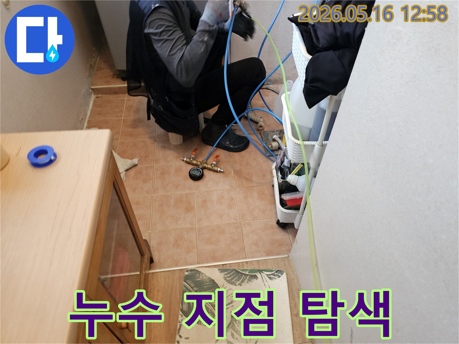 누수-전문가가-누수-지점을-정확히-탐색하기-위해-압력-테스트-장비를-설치하는-모습
