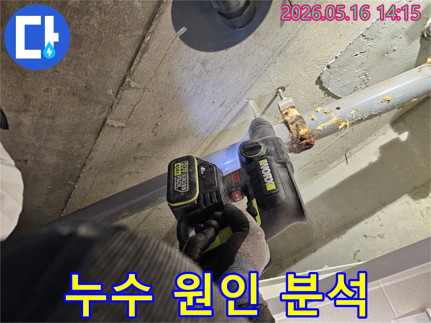 누수 전문가가 천장 배관의 누수 원인을 분석하기 위해 드릴로 콘크리트를 타공하는 모습-정확한 진단을 위한 작업입니다.
