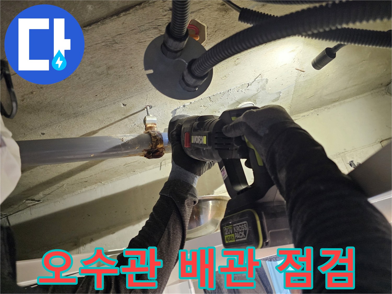 아파트 화장실 천장 내부 오수관 연결 부위를 전동 드릴로 점검하는 모습