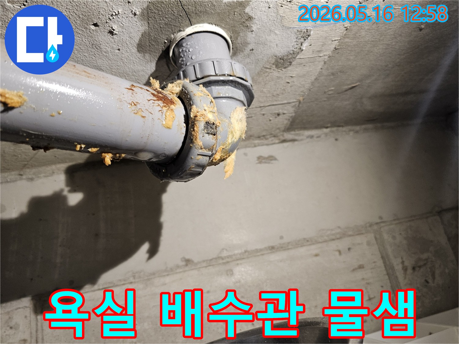 욕실-천장-아래-배수관-연결부에서-물이-새어-나와-단열재가-젖은-모습을-보여주는-누수-현장-사진