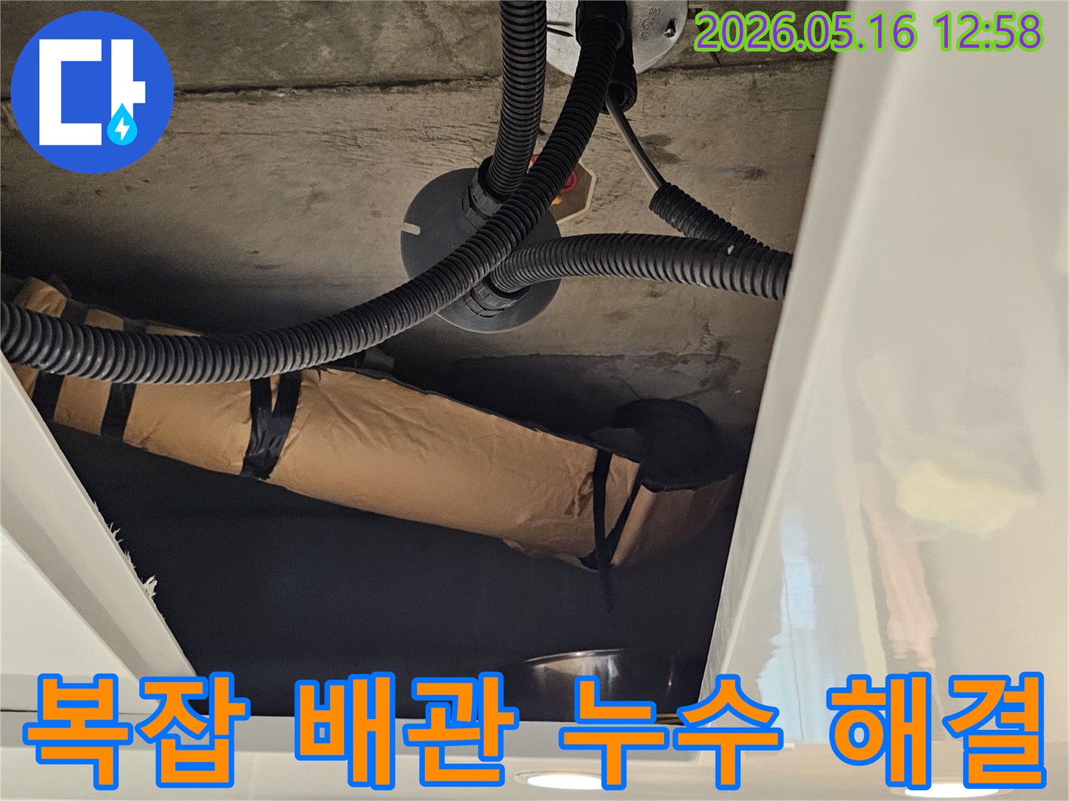 이 사진은-누수 공사 중-벽면 안쪽의-복잡한 배관 구조를-명확히 보여주고 있습니다