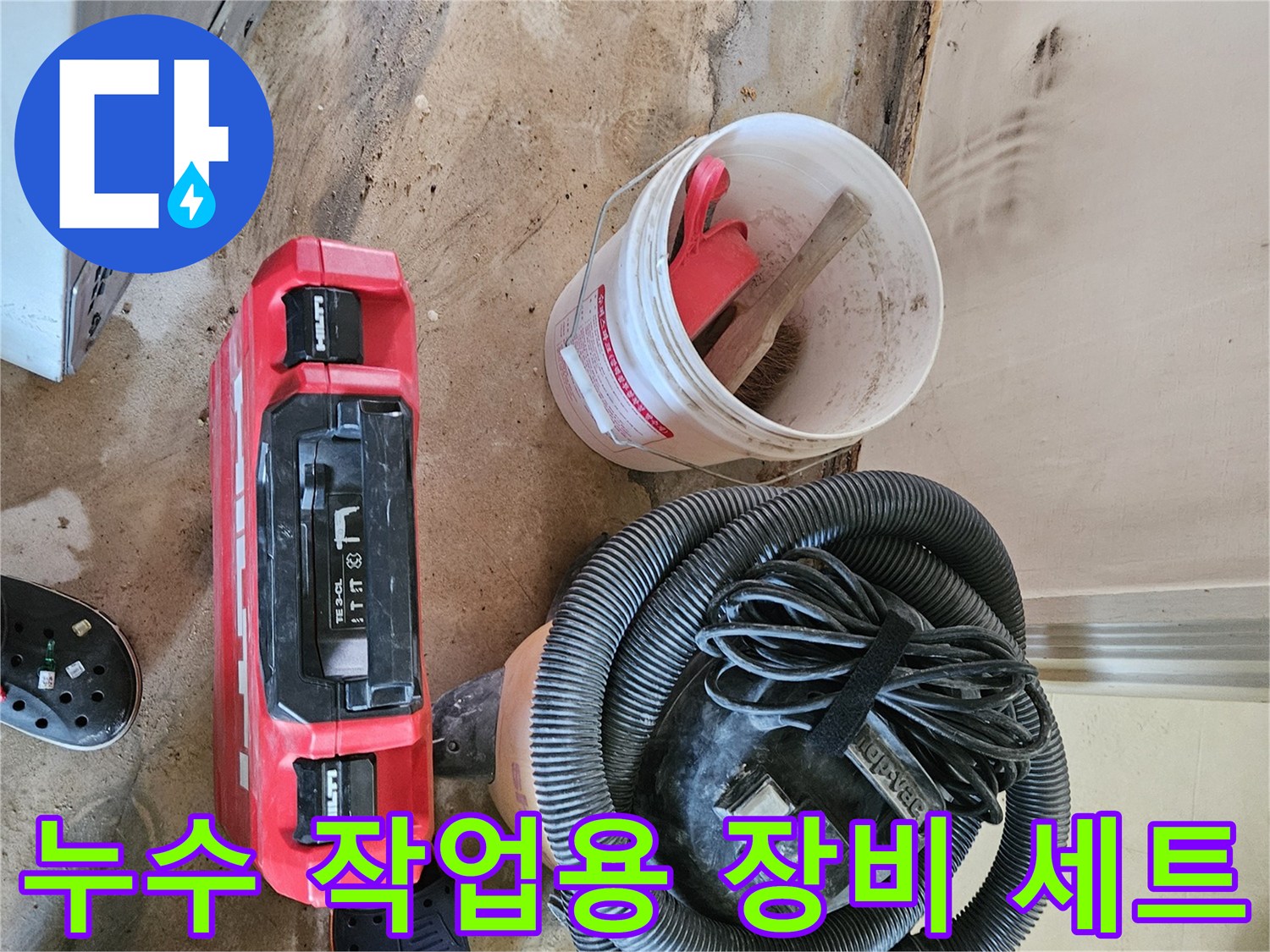 누수 현장에 놓인 산업용 청소기와 빨간 공구함