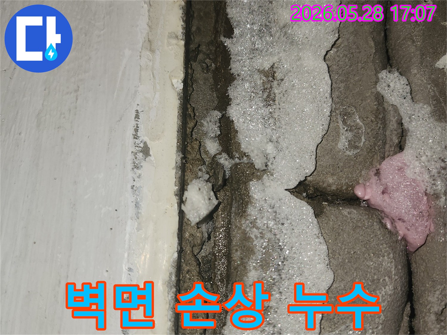 문틈-사이로-물이-새어-나와-벽면이-손상된-세탁실-누수-현장의-클로즈업-사진입니다