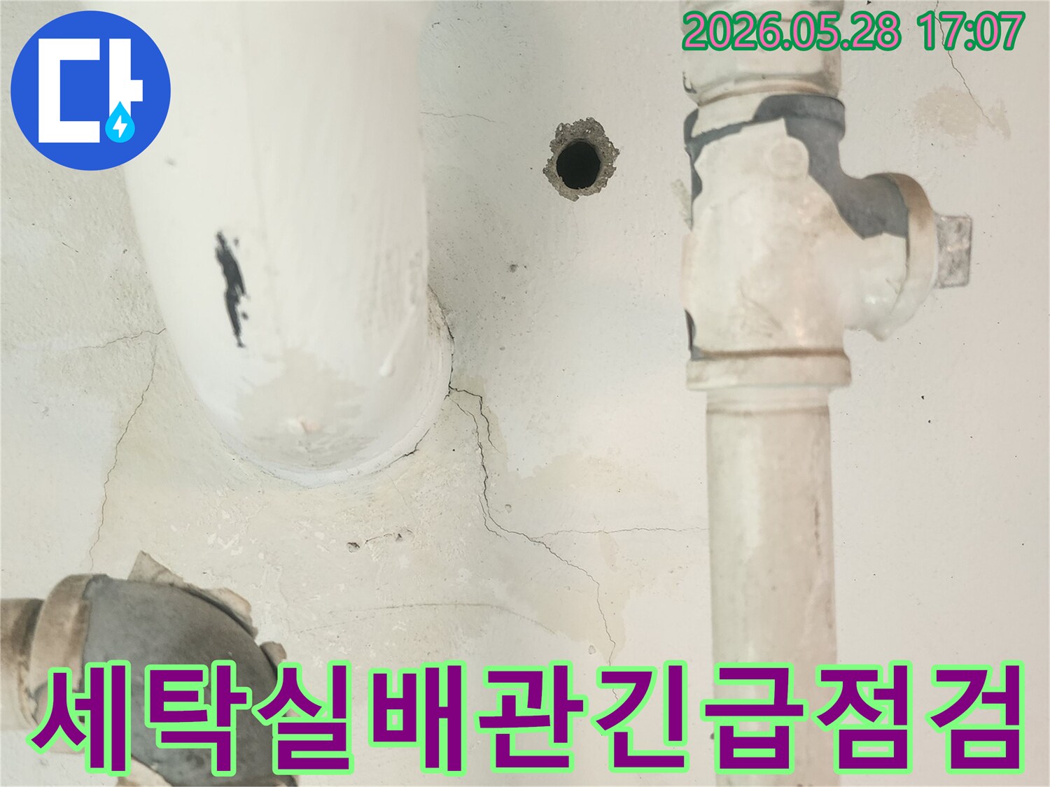 세탁실 공용배관 주변의-벽면 균열과 물 자국을-자세히 관찰하는 모습입니다.