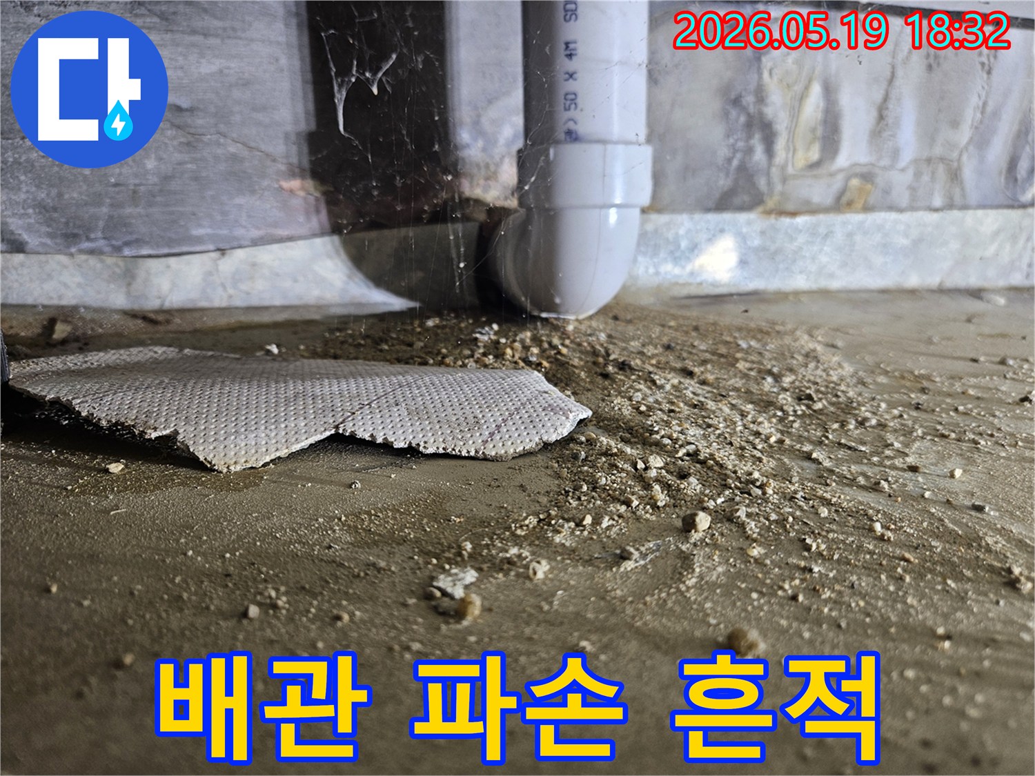 누수 탐지 중 발견된-배관 하부의 물 고임과 흙먼지-손상된 바닥면