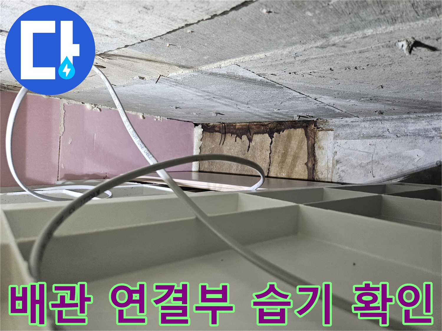 배수관 주변의 벽면 변색과 습기 발생 부위를 근접 촬영한 사진입니다.