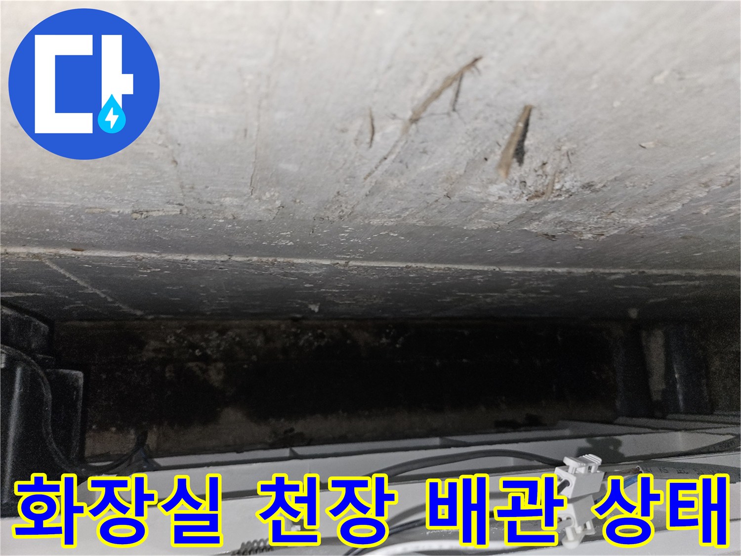 화장실 천장 내부의 배관 연결 부위와 습기가 찬 콘크리트 면