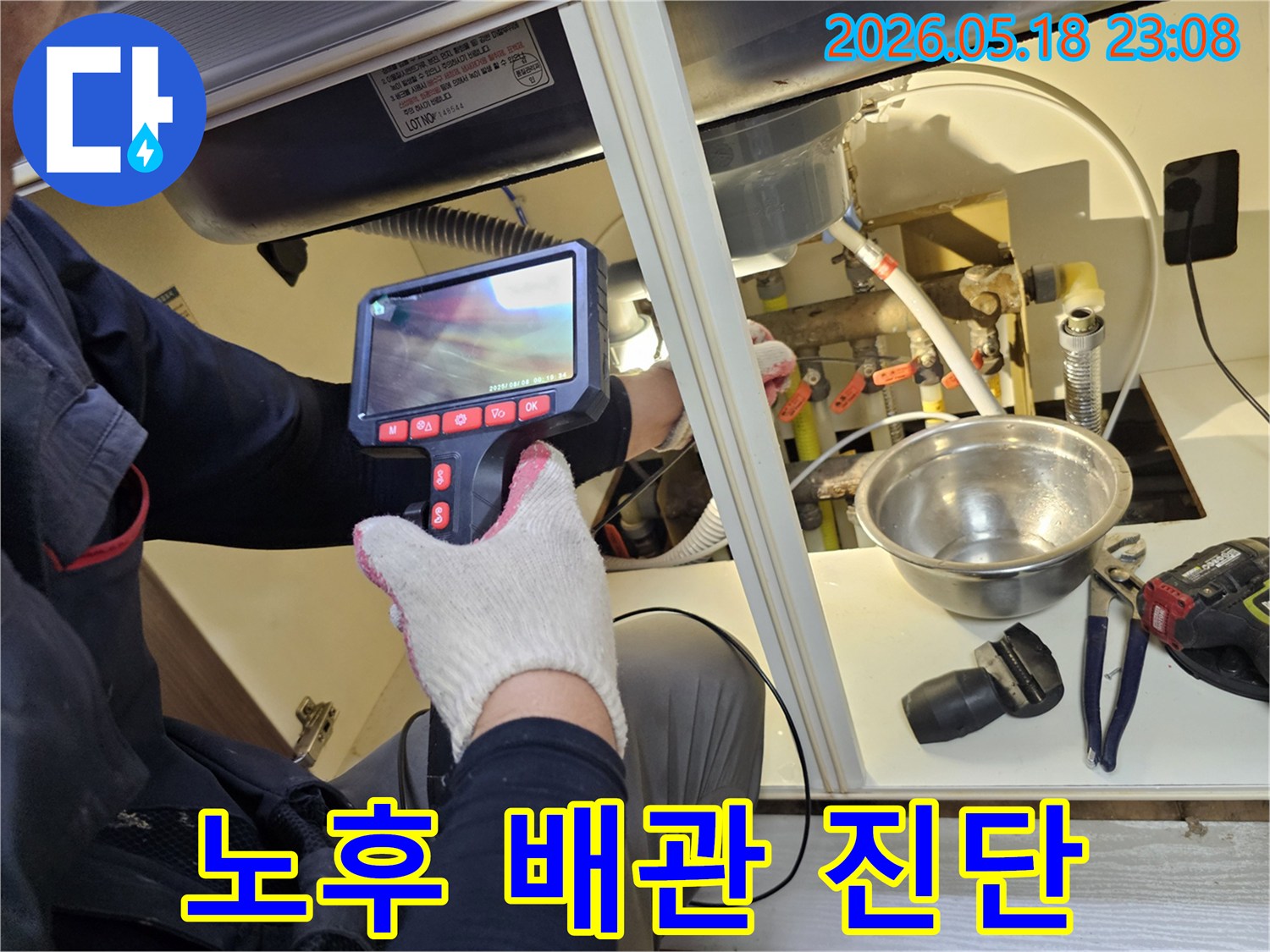 엔지니어가 싱크대 하부의-노후된 배관 상태를-내시경으로 면밀히 검토하며-누수 발생 가능성을 진단하고 있습니다.
