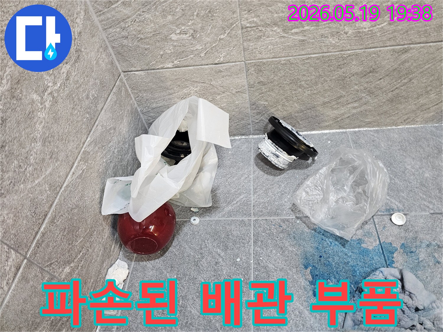 누수 탐지 작업 중-욕실 바닥에서 발견된-오래된 배관 부품과-염료 흔적