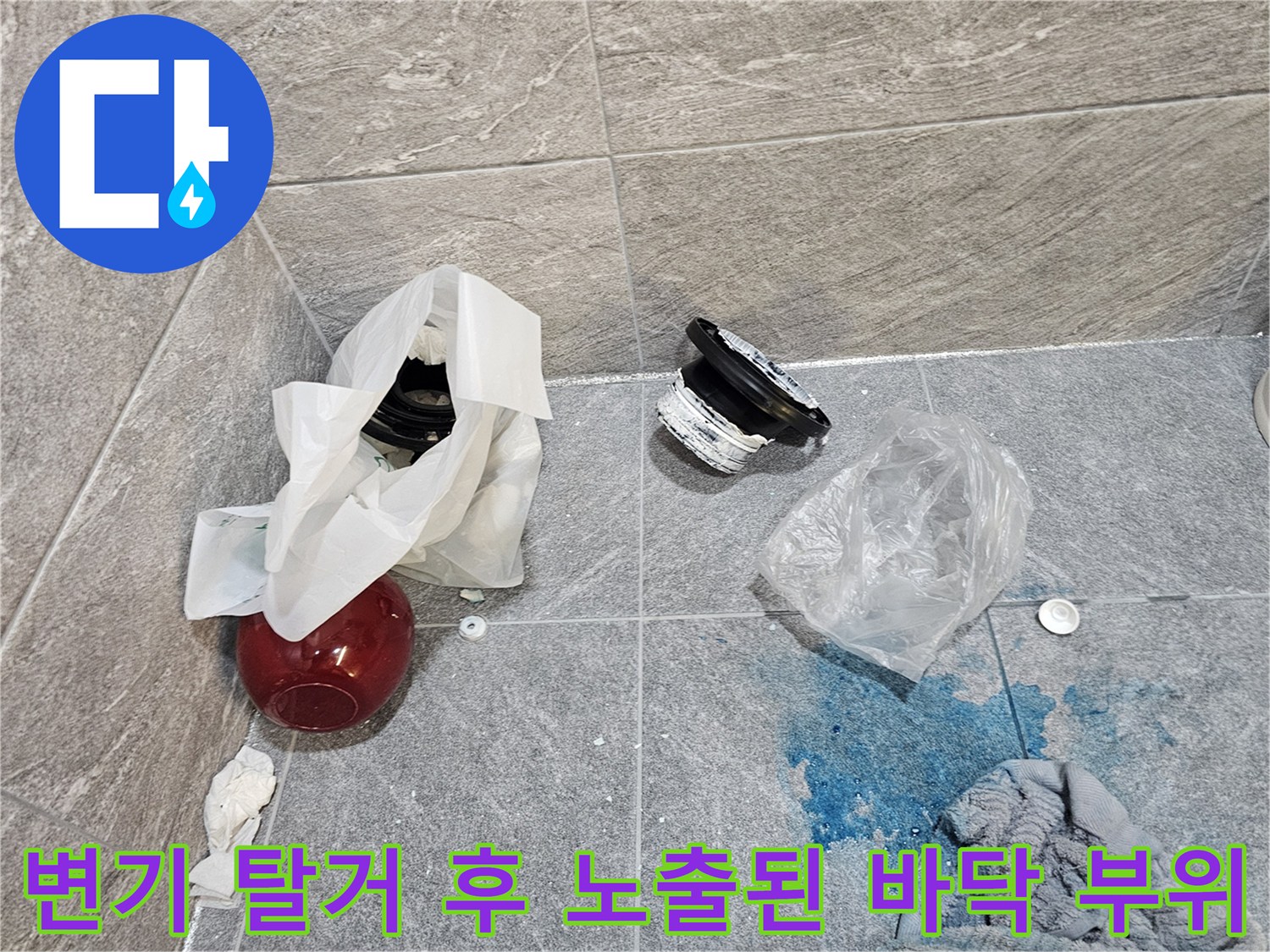 변기를 들어낸 뒤 드러난 오수관 주변 부품과 젖은 타일
