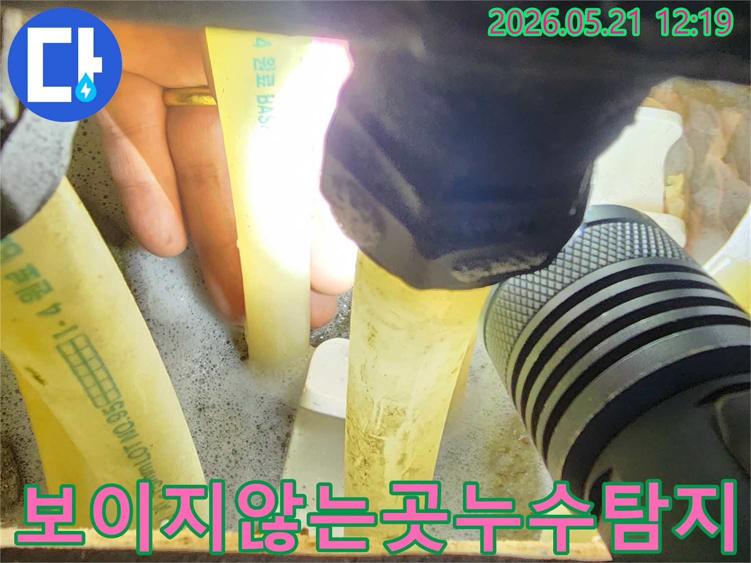 누수-엔지니어가-손전등으로-어둡고-협소한-공간의-배관을-비춰-보이지-않는-누수-지점을-탐지하는-장면