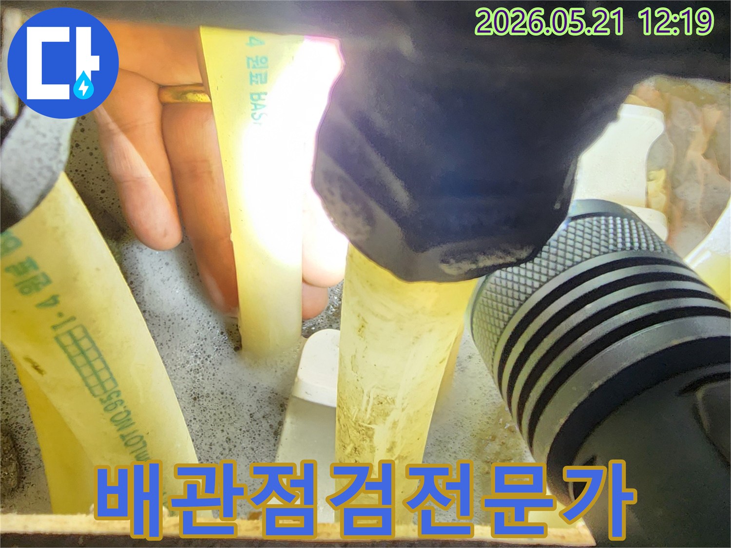 누수-전문가가-손전등으로-배관-상태를-정밀하게-점검하며-누수-지점을-찾아내는-모습