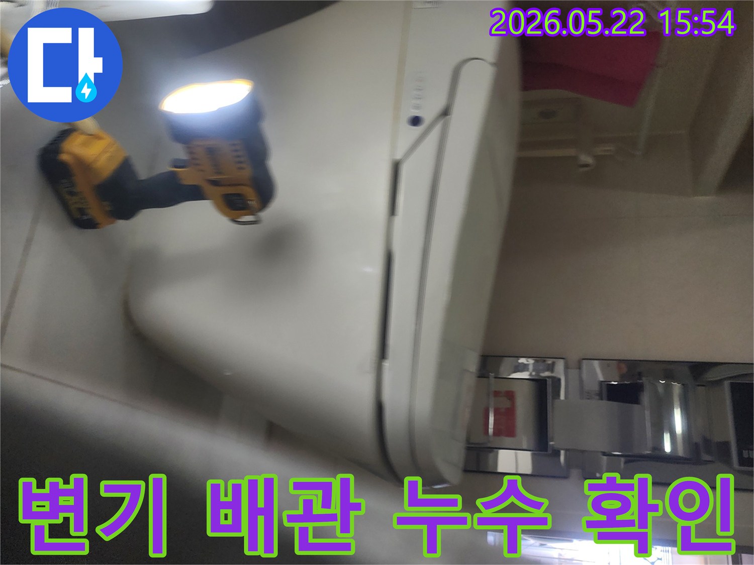 기흥구 화장실에서-변기 배관 누수 여부를-확인하기 위해-작업등을 사용해-세밀하게 점검하는-누수 전문가의 작업 현장
