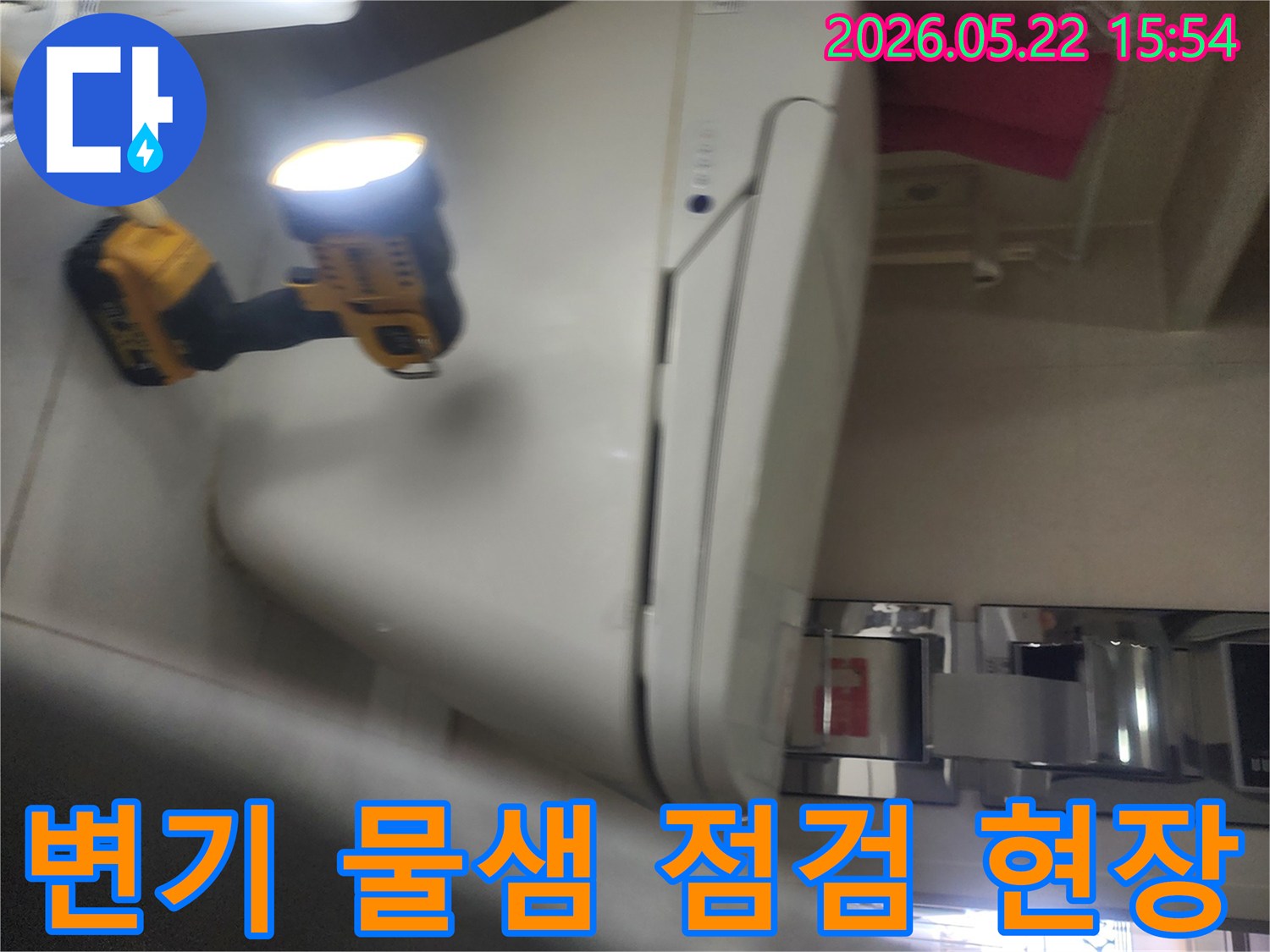 용인 아파트 욕실에서-변기 주변의 물샘 현상을-정확히 파악하기 위해-작업등을 비추며-세밀하게 점검하는-누수 탐지 전문가의 모습